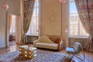 Salon parisien lumineux avec rideaux fleuris et mobilier contemporain